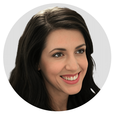 Smiling woman with dark hair against a light gray background.